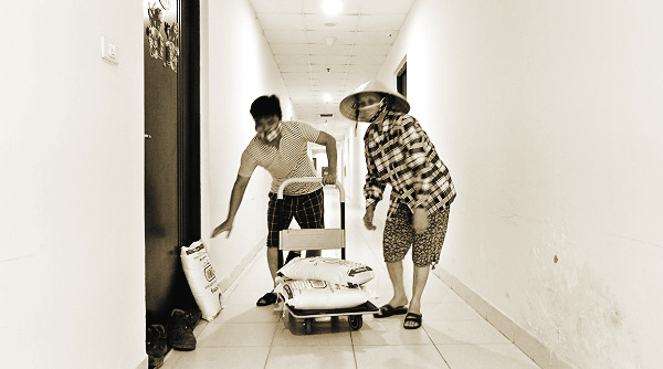 Các tình nguyện viên đưa gạo đến các tầng trong khu chung cư bị phong toả, cách ly