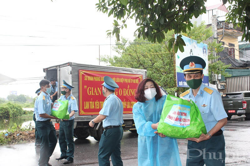 Các thành viên trong đoàn công tác chuyển các phần quà tới điểm chốt trực tại thôn Phương Nhị xã Liên Ninh