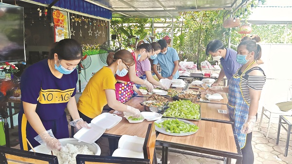 Anh Nguyễn Duy Anh (thứ 5 b&ecirc;n tr&aacute;i) tham gia c&ugrave;ng c&aacute;c chị em phụ nữ ở x&atilde; Thượng Mỗ, huyện Đan Phượng chuẩn bị bữa trưa cho c&aacute;c chốt trực