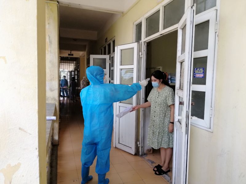 C&aacute;n bộ y tế đo nhiệt độ của người đang c&aacute;ch ly tại khu KTX Cao đẳng Truyền h&igrave;nh