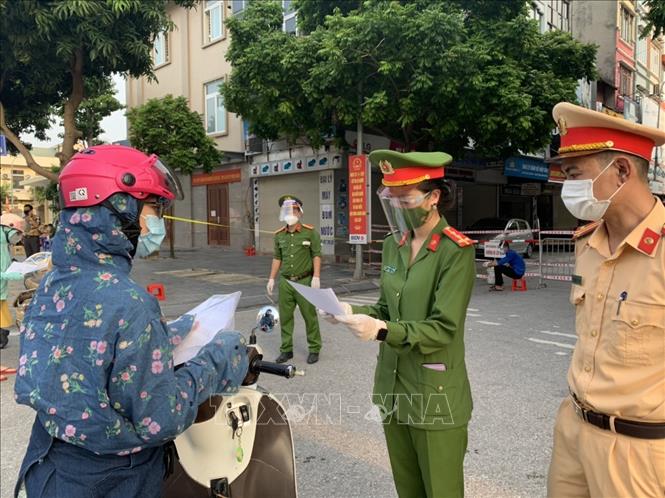 Công an huyện Đông Anh kiểm tra giấy đi đường của người dân trên đường Cao Lỗ, trung tâm thị trấn Đông Anh - nơi tập trung các cơ quan hành chính nhà nước. Ảnh: Nguyễn Văn Cảnh/TTXVN