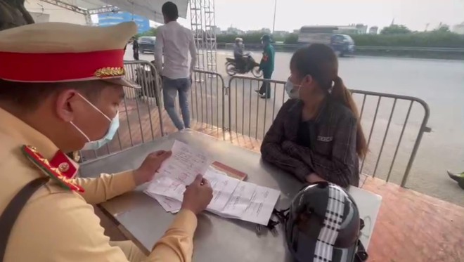 Lực lượng chức năng kiểm tra giấy đi đường của đ&ocirc;i nam nữ
