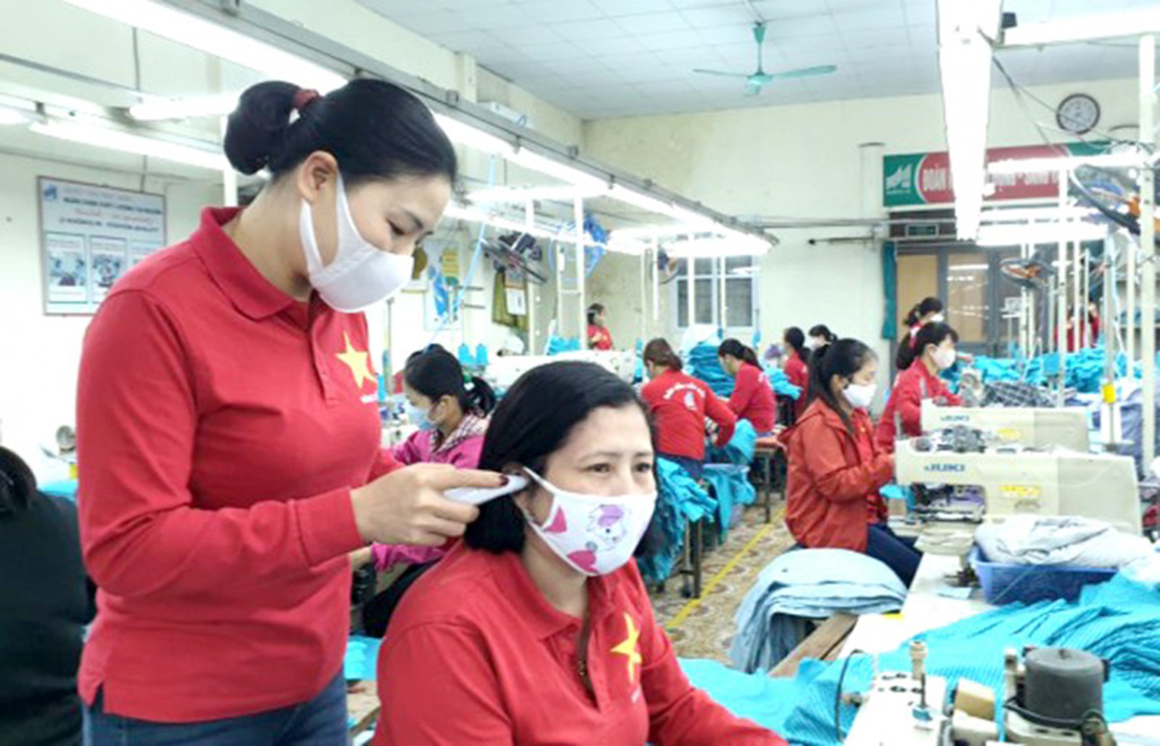 Kiểm tra thân nhiệt của người LĐ tại dây chuyền sản xuất Công ty TNHH May Phù Đổng.