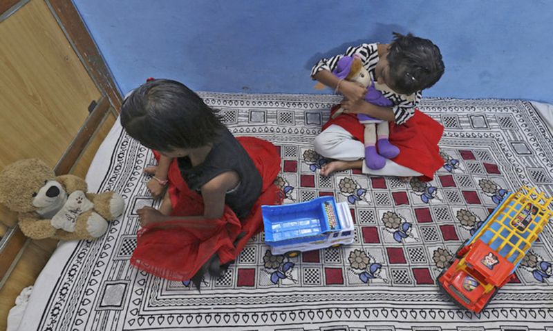 Hai chị em song sinh tại Ấn Độ mất bố mẹ vì Covid-19 được chuyển đến sống cùng họ hàng tại tỉnh Bhopal vào tháng 6. Ảnh: AFP