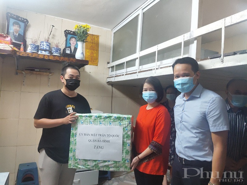 Các đại biểu đại diện Ban Dân vận, MTTQ quận tặng quà cho gia đình