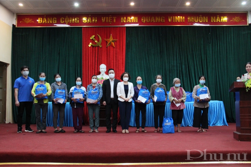 Đồng chí Phạm Thị Thanh Hương - Phó Chủ tịch Hội LHPN Hà Nội và đồng chí Đinh Đức Thiện - Giám đốc trường Đào tạo cán bộ (Bộ Thông tin và Truyền thông) tặng quà cho phụ nữ công giáo có hoàn cảnh khó khăn xã Tân Minh.