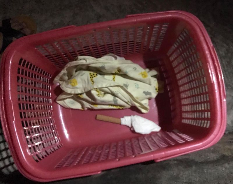 Ch&aacute;u b&eacute; được đặt trong một chiếc l&agrave;n c&ugrave;ng một số vật dụng.