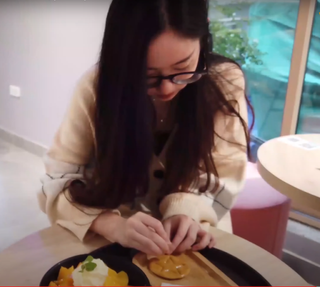 Một khách hàng đang thực hiện trò chơi tách kẹo giống trên phim "Trò chơi con mực" tại quán cafe