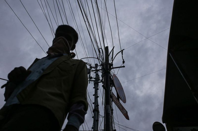 Một người dân đi bộ dưới đường dây điện ở Bengaluru, Ấn Độ