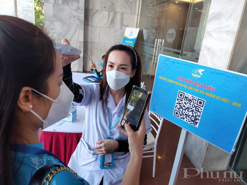 Các đại biểu nghiêm túc thực hiện phòng chống dịch đo nhiệt độ và quét mã QR khai báo y tế .