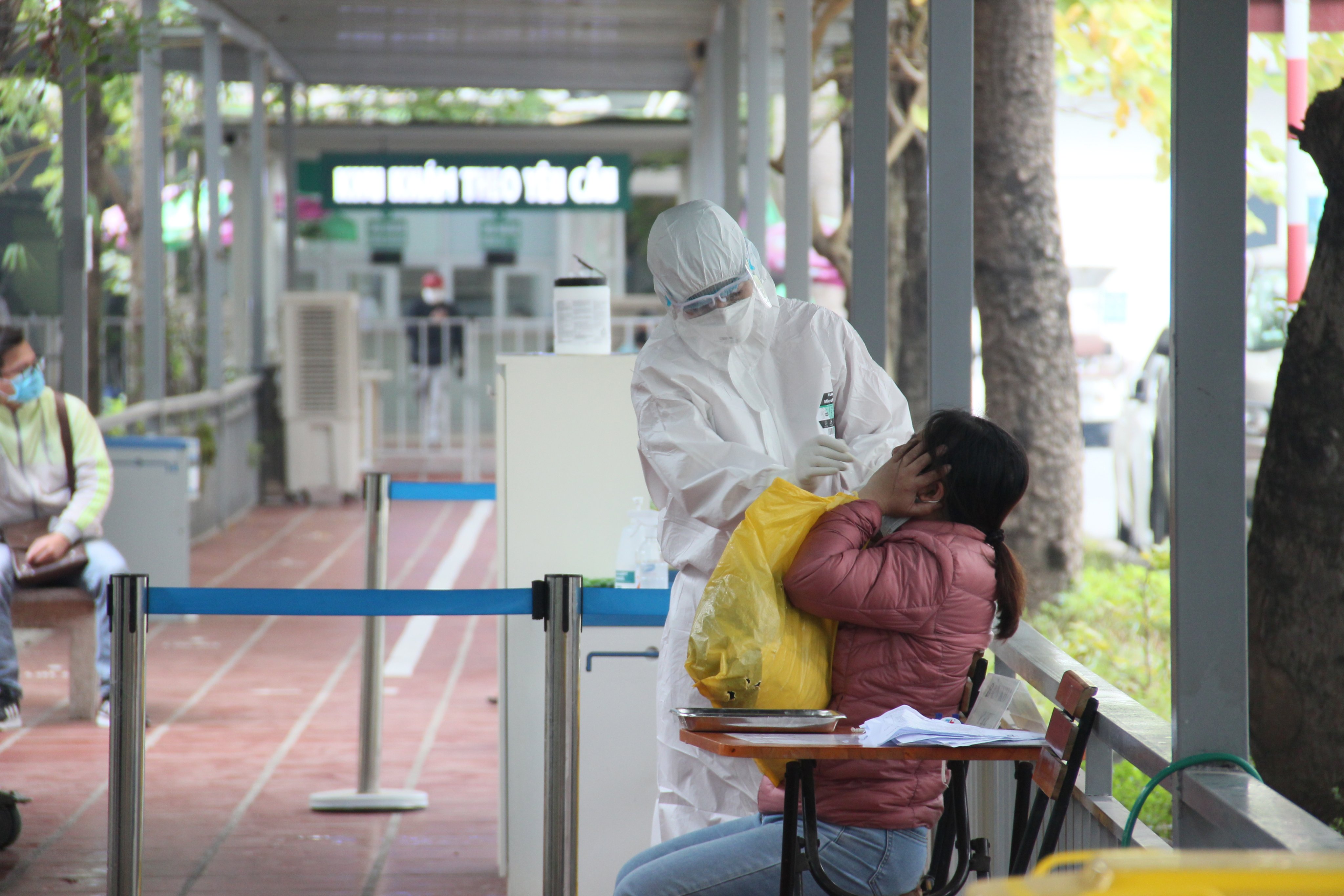 Nhân viên y tế bệnh viện Thanh Nhàn lấy mẫu xét nghiệm cho trường hợp có dấu hiệu nghi nhiễm tới khám tại bệnh viện.