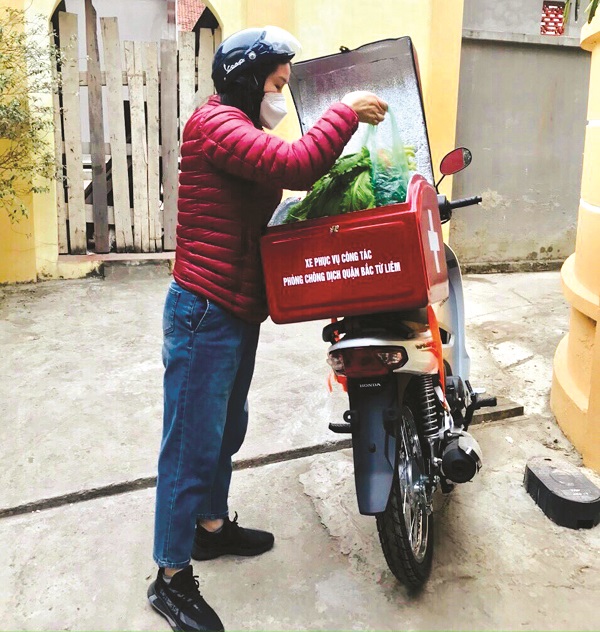 Chủ tịch Hội LHPN phường Xuân Đỉnh, Lê Thị Lý, chuyển thuốc và thực phẩm đến các gia đình có F0