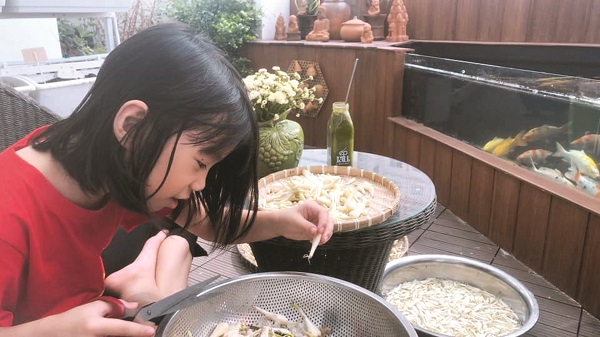 B&eacute; Su, con g&aacute;i &uacute;t của chị Hiền gi&uacute;p mẹ muối kiệu Tết