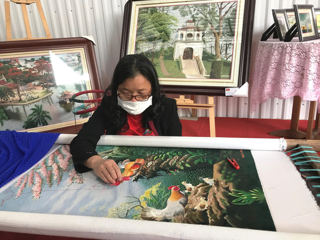 Nghệ nh&acirc;n Ho&agrave;ng Thị Khương b&ecirc;n bức tranh th&ecirc;u phong cảnh - Ảnh: VGP/Diệu Anh