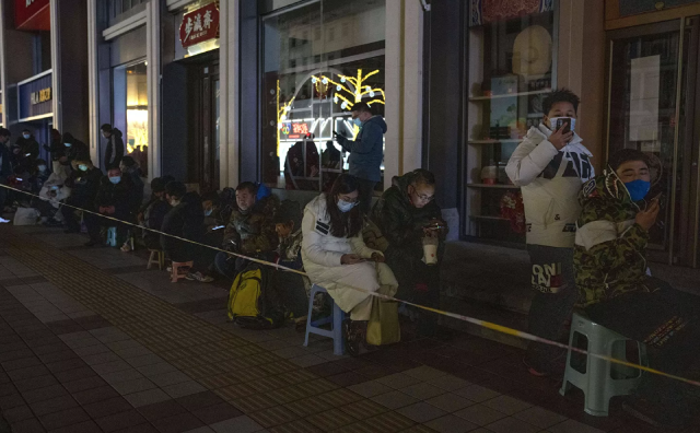 Người hâm mộ xếp hàng dọc theo con hẻm Wangfujing (Bắc Kinh) gần trung tâm thương mại Gongmei Emporium để mua linh vật Bing Dwen Dwen của Thế vận hội.