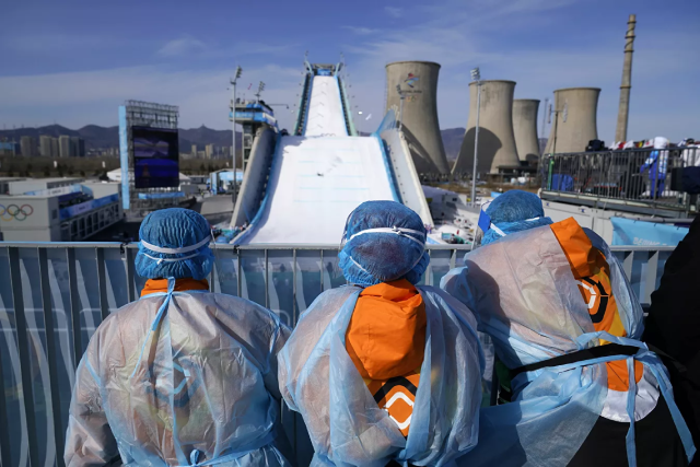 Nhân viên phục vụ xem vòng loại tự do đồng đội nữ môn Big Air (nhào lộn trên không).