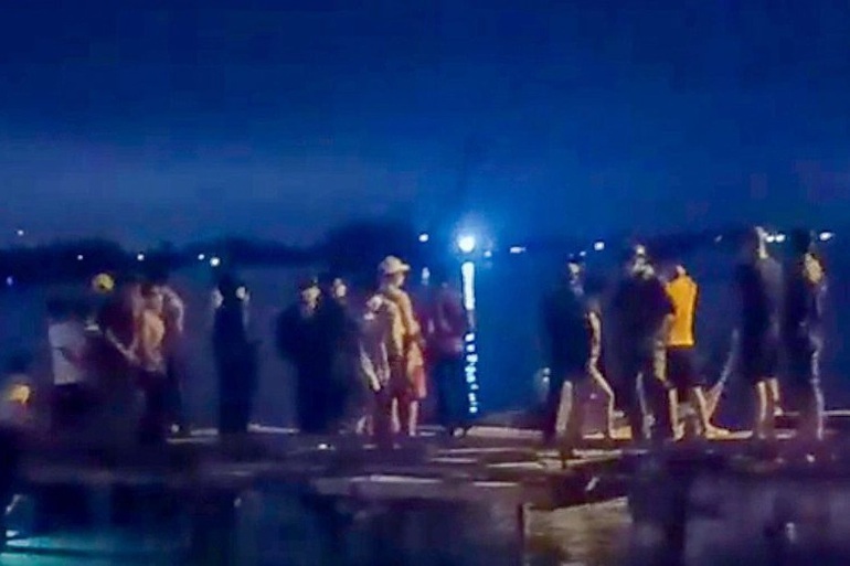 Người dân tập trung ra chỗ Viên ném con xuống sông để tìm kiếm (Ảnh: CTV).