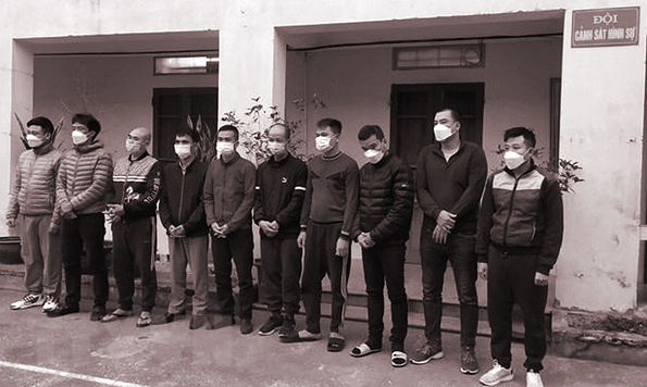 Đối tượng cầm đầu Nguyễn Xuân Tiến (đứng thứ 3, từ phải sang) cùng 9 đối tượng khác tại cơ quan công an. (Ảnh: TTXVN)