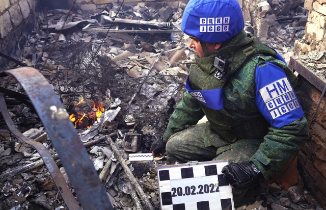 Đại diện Trung tâm Kiểm soát và điều phối chế độ ngừng bắn (SCKK) của LNR gần ngôi nhà bị Lực lượng Vũ trang Ukraina tấn công bằng pháo tại làng Pionerskoye, Cộng hòa Nhân dân Luhansk.