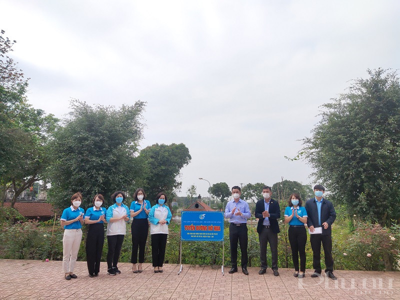 Các đại biểu tham gia gắn biển tuyến đường nở hoa tại khuân viên khu vực đền Mẫu do phụ nữ đảm nhiệm