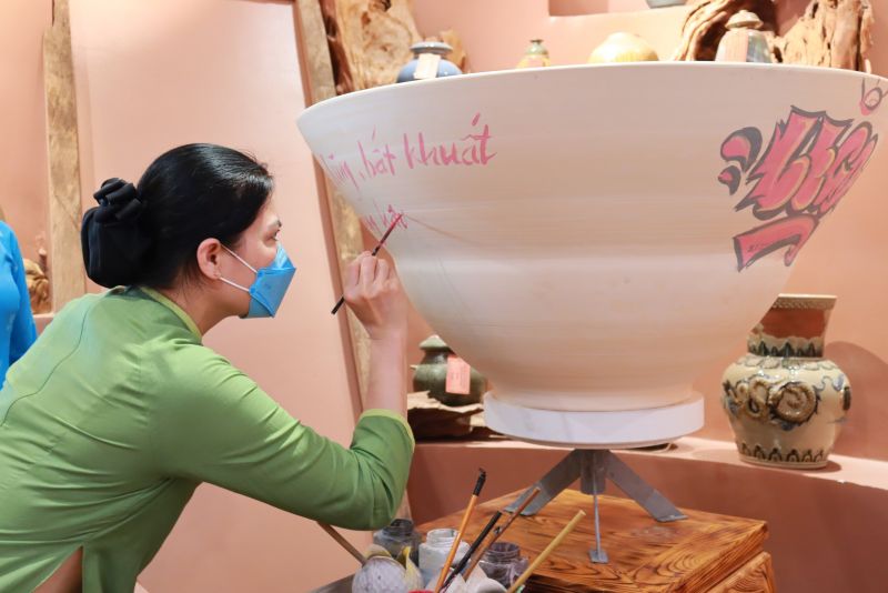 Chủ tịch Hội LHPN Việt Nam Hà Thị Nga viết lên một tác phẩm gốm ca ngợi các phẩm chất của người phụ nữ Việt Nam Anh hùng-Bất khuất-Trung hậu-Đảm đang