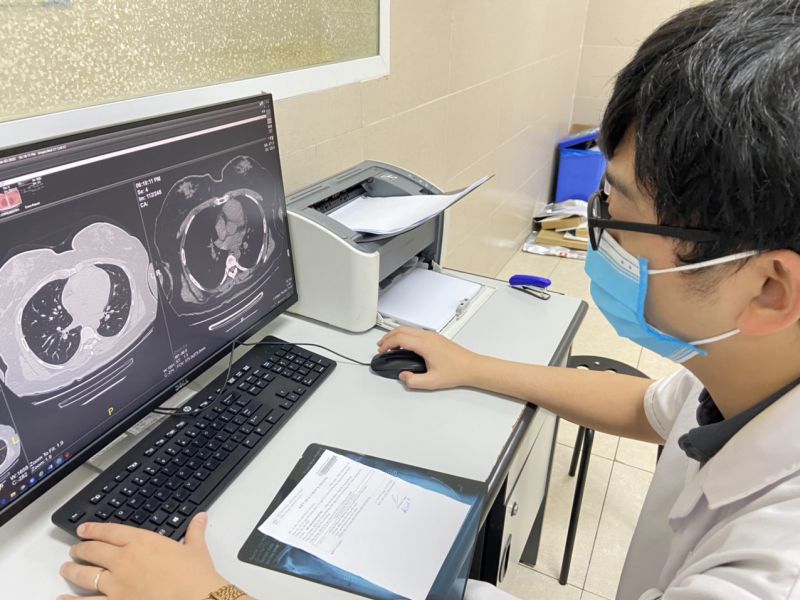 Nhân viên y tế bệnh viện Đa khoa Thanh Nhàn kiểm tra tổn thương phổi cho bệnh nhân sau khi mắc Covid-19. 	Ảnh: BVCC