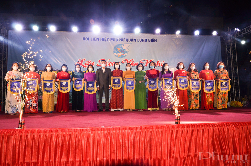 Đồng chí Nguyễn Quốc Long - Ủy viên Thường vụ, Trưởng ban Dân vận Quận ủy và Đồng chí Đào Thu Hải – Quận Ủy viên, Chủ tịch Hội LHPN Quận đã lên sân khấu tặng cờ lưu niệm cho 14 đơn vị hội viên tại các cơ sở trên địa bàn.