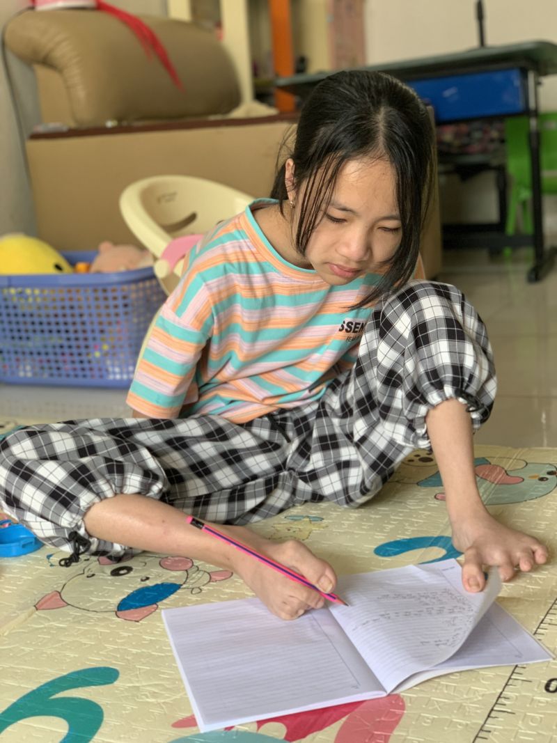 Dù không có tay, bé Linh vẫn có thể tự viết bằng đôi chân bé bỏng của mình 	Ảnh: Q.An