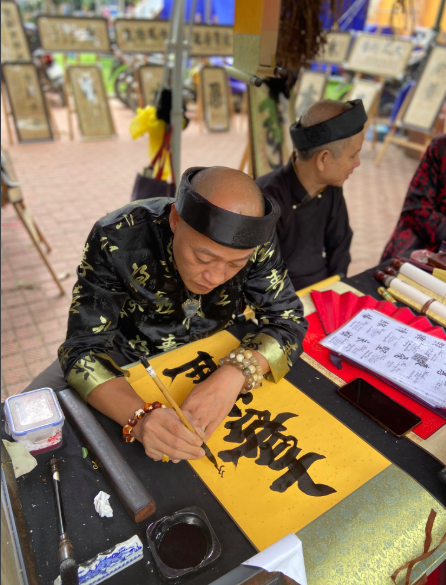 Gian viết chữ thư pháp được du khách quan tâm.