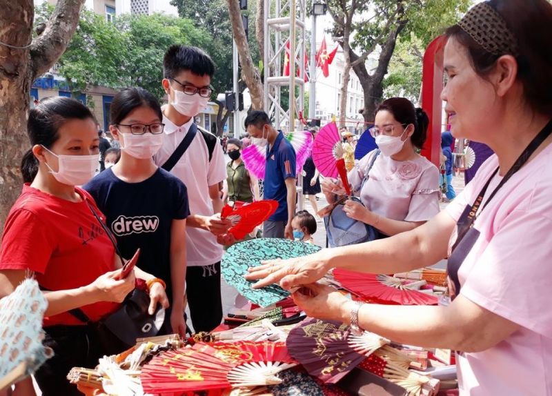 Khách du lịch  tham quan và mua quạt giấy Chàng Sơn (Thạch Thất) tại Lễ hội quà tặng du lịch Hà Nội 2022