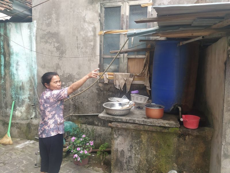 Một người dân xã Liên Hà bên hệ thống bơm, lọc nước giếng khoan thủ công trong thời gian chờ có nước sạch