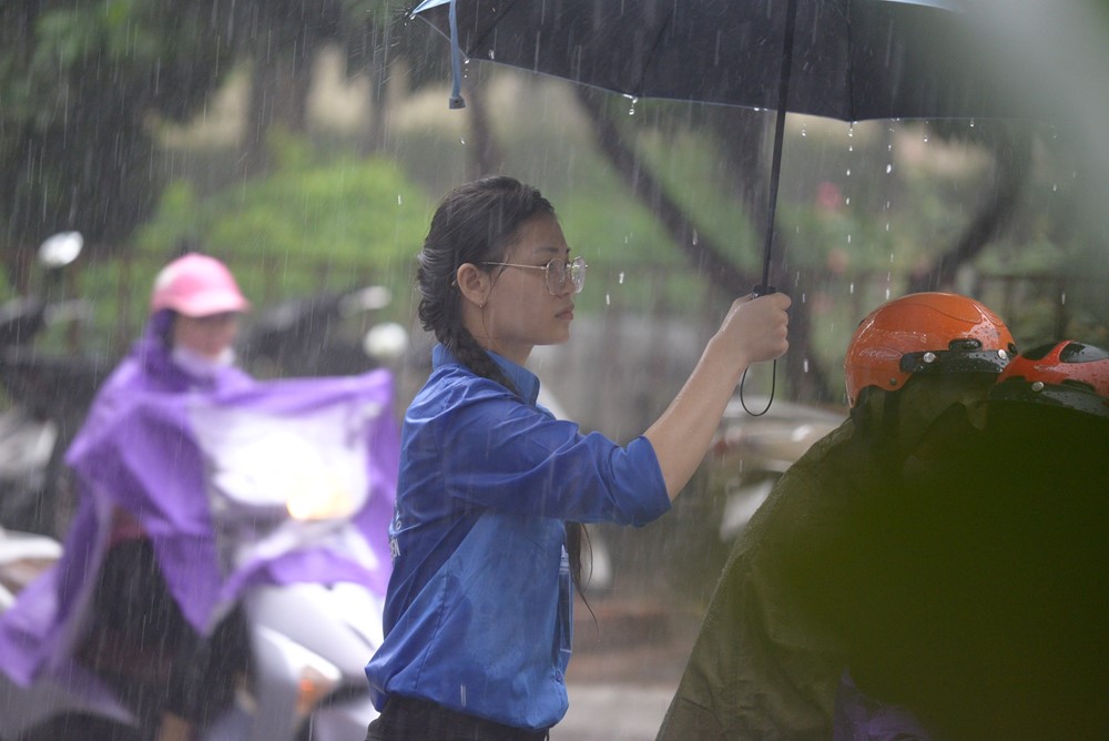 Tình nguyện viên đội mưa che cho thí sinh dự thi vào trường THPT chuyên ĐH Sư phạm Hà Nội - ảnh 7