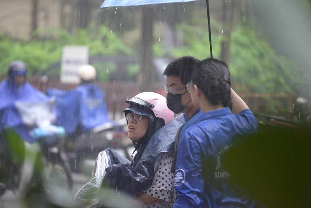 Tình nguyện viên đội mưa che cho thí sinh dự thi vào trường THPT chuyên ĐH Sư phạm Hà Nội - ảnh 11