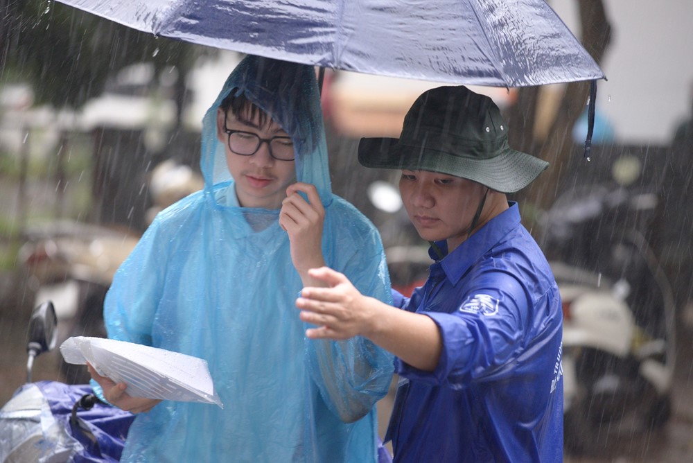 Tình nguyện viên đội mưa che cho thí sinh dự thi vào trường THPT chuyên ĐH Sư phạm Hà Nội - ảnh 10