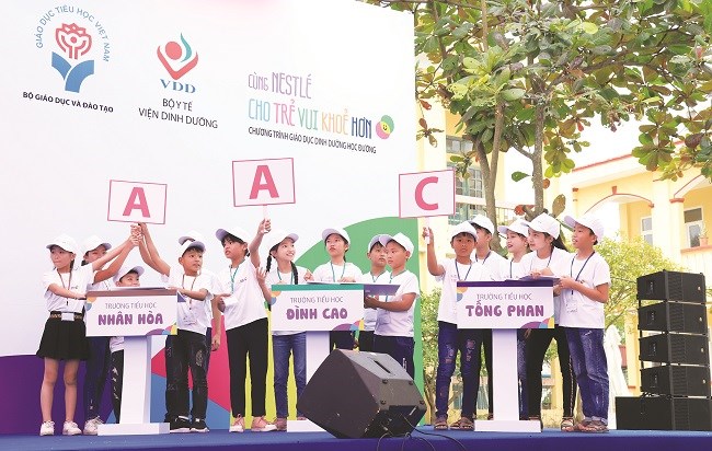 Các em học sinh 05 trường tiểu học tỉnh Hưng Yên thể hiện kiến thức dinh dưỡng và vận động thể lực trong hoạt động giao lưu giữa các trường trên sân khấu.