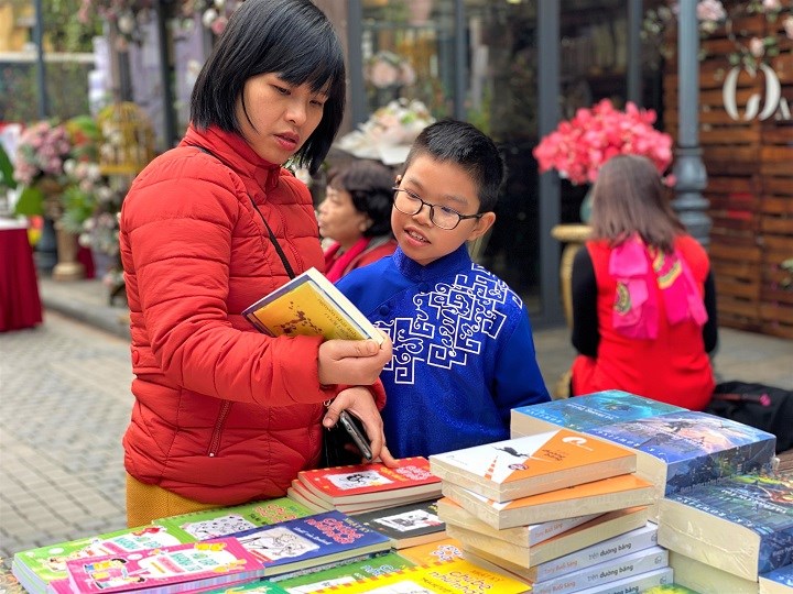 Các em nhỏ được bố mẹ đưa đến Phố sách Xuân Canh Tý để lựa chọn những cuốn sách, tác phẩm văn học yêu thích.