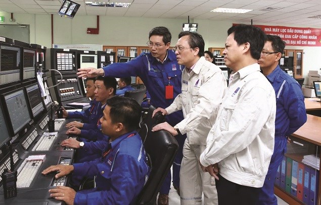 Tổng giám đốc Công ty CP Lọc hóa dầu Bình Sơn Bùi Minh Tiến (giữa) kiểm tra công tác vận hành tại Phòng điều khiển trung tâm trong dịp Tết Nguyên đán