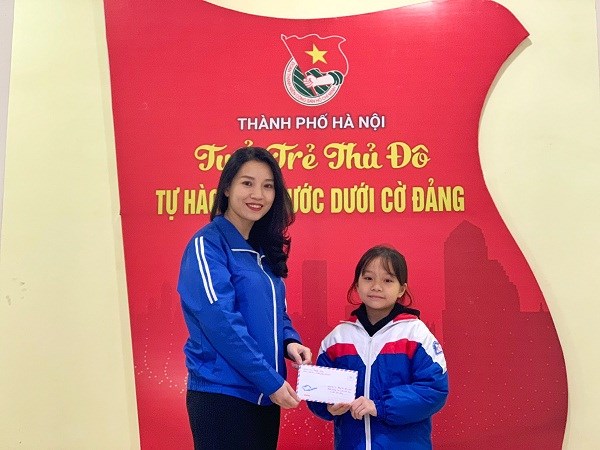 đồng chí Bùi Lan Phương Phó Chủ tịch Thường trực Hội đồng Đội Thành phố nhận số tiền ủng hộ của em Ngọc Trinh