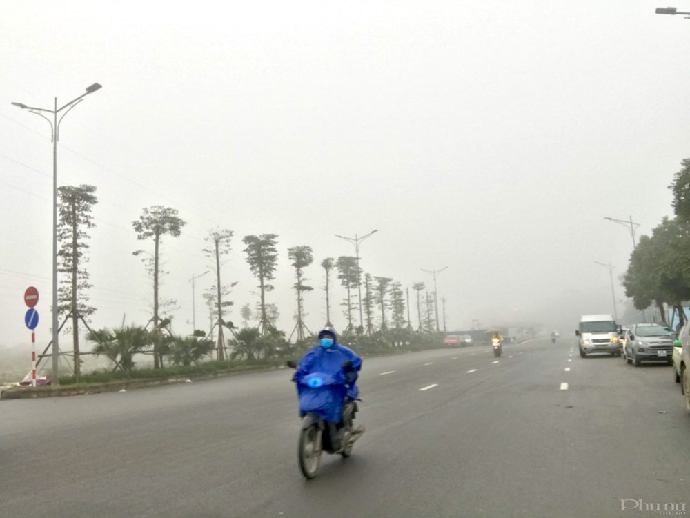 Sương mù kèm mưa phùn lất phất, ẩm ướt nên nhiều người dân phải mặc thêm áo mưa khi di chuyển trên đường.