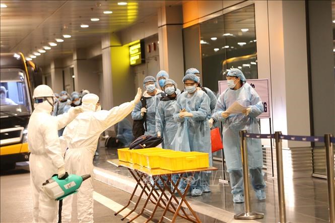 Công dân Việt Nam được hướng dẫn tẩy trùng trước khi làm thủ tục nhập cảnh tại sân bay Vân Đồn.