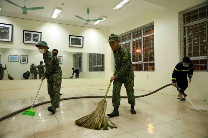 Lực lượng công an, bộ đội dọn vệ sinh các phòng dùng để làm bệnh viện dã chiến.