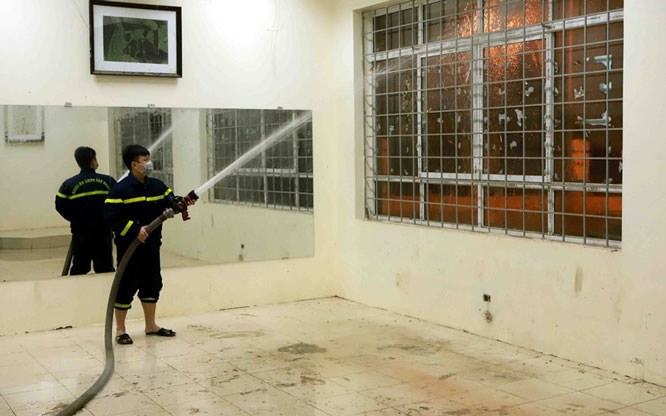 Lính cứu hỏa phun nước vệ sinh các phòng dùng để làm bệnh viện dã chiến