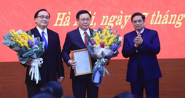 Đồng chí Phạm Minh Chính - Ủy viên Bộ Chính trị, Trưởng ban Tổ chức Trung ương tặng hoa cho hai đồng chí Vương Đình Huệ và Hoàng Trung Hải.