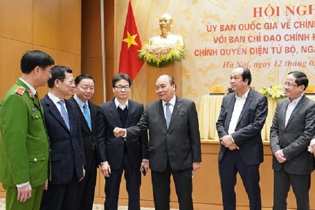 Thủ tướng Nguyễn Xuân Phúc, Phó Thủ tướng Vũ Đức Đam trao đổi với lãnh đạo các bộ, ngành bên lề hội nghị.
