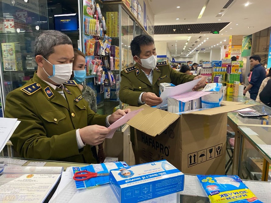 Cán bộ Đội Quản lý thị trường số 1 (Cục Quản lý thị trường Hà Nội) kiểm tra lô khẩu trang tại một hiệu thuốc trên địa bàn thành phố.