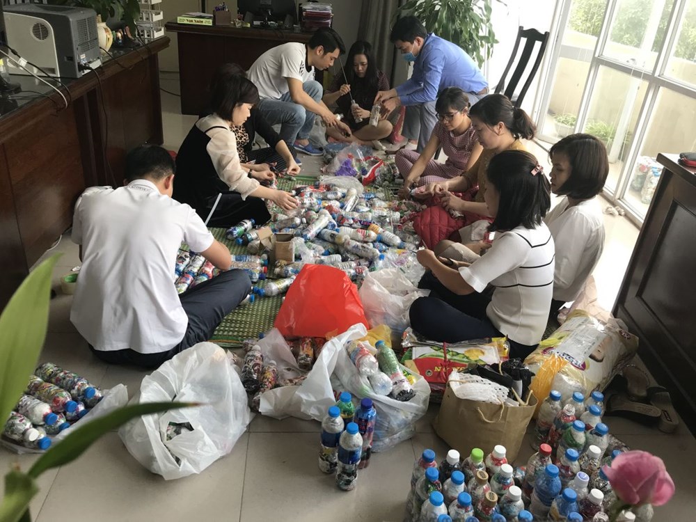 Các đoàn viên thanh niên Chi đoàn Hội LHPN Hà Nội tái chế rác thải nhựa thành những viên gạch sinh thái để làm bàn, ghế tặng các bạn học sinh.
