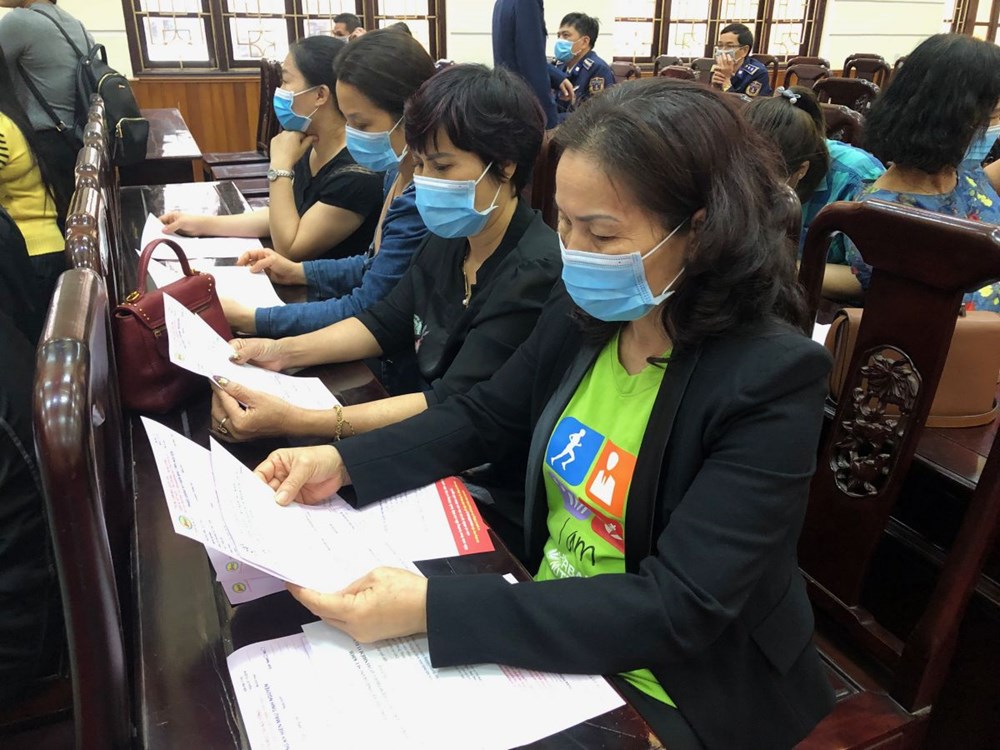Hội viên phụ nữ điền bảng hỏi tình trạng sức khỏe và phiếu đăng ký hiến máu tình nguyện