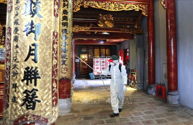 Nhân viên Sở y tế Hà Nội phun thuốc tiêu độc khử trùng bên trong đền Bà Kiệu.