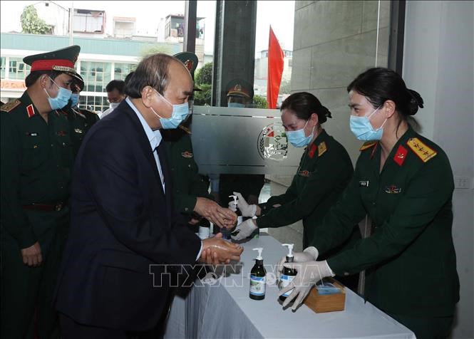 Thủ tướng Nguyễn Xuân Phúc rửa tay sát khuẩn trước khi vào họp. Ảnh: Thống Nhất/TTXVN