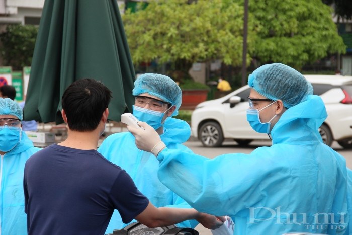 Bác sĩ bệnh viện Bạch Mai kiểm tra thân nhiệt cho người ra vào tại bệnh viện.